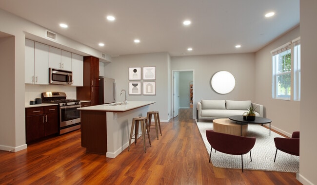 Renovated kitchen with an island, quartz countertops, and hardwood floors