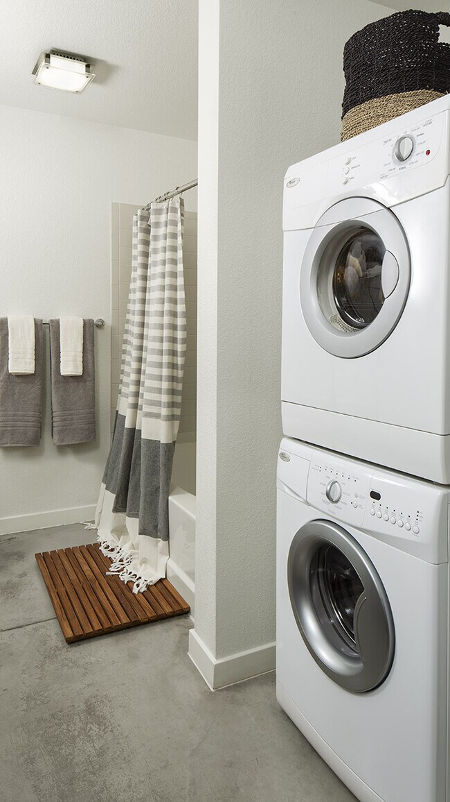 Apartment Bathroom with soaking tub and in-home washer and dryer.