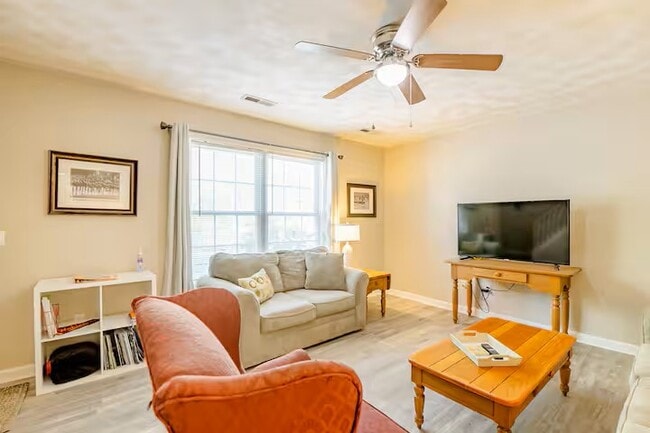 La sala de estar cuenta con sofá, sofá de dos plazas y sillón, además de un televisor inteligente de 50 pulgadas. - 515 School Ln