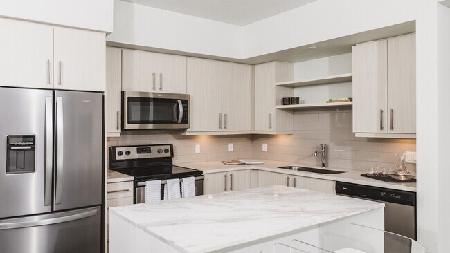 Stunning kitchens with french door stainless steel refrigerators, quartz counters, tile backsplash, and built in shelving
