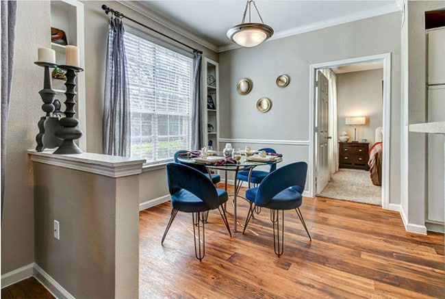 Comedor con ventana grande, pisos estilo madera, iluminación renovada y que conduce al habitación - Colonnade