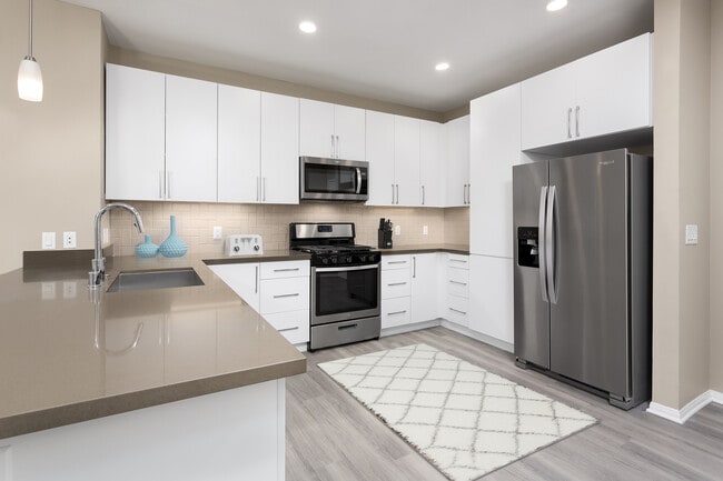Newly renovated Design Scheme I kitchen with new cabinets, quartz countertops, stainless steel appliances, and hard surface plank flooring