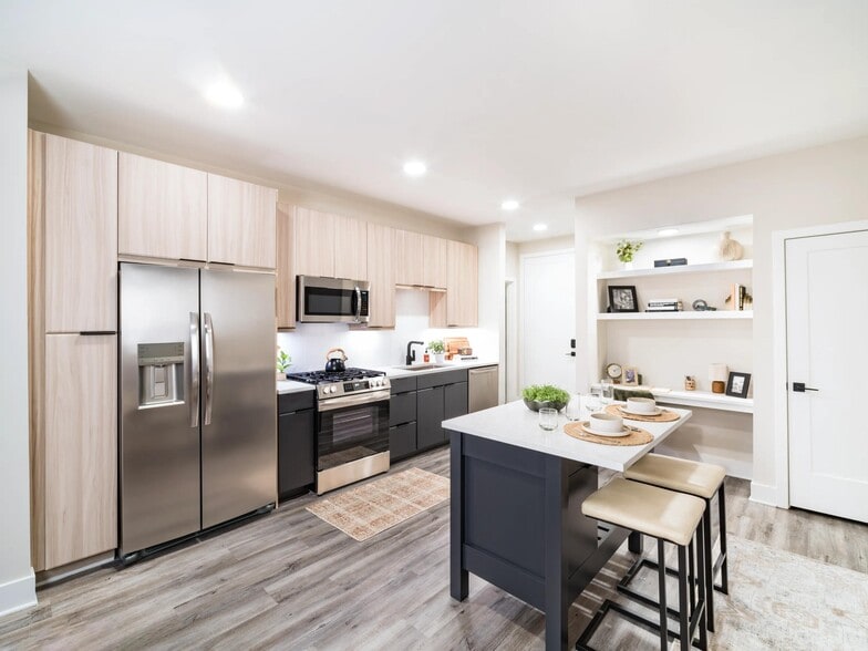 A light-filled kitchen with an oversized island, open shelving, and clean-lined finishes that support everyday cooking and casual dining.