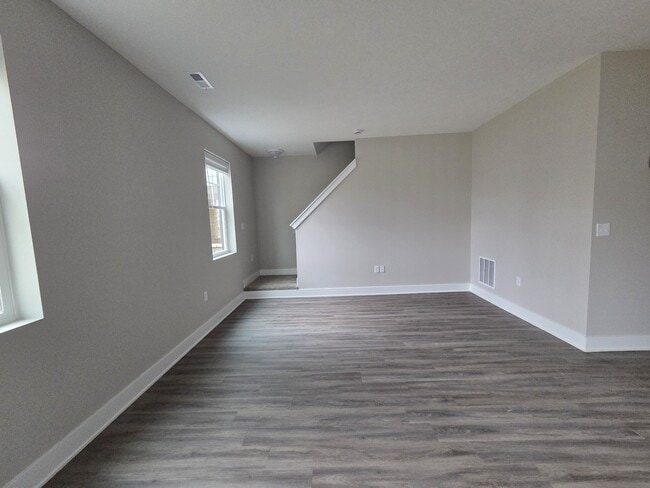 Townhome living area and stairs leading to second level. - Flats at Sugar Run