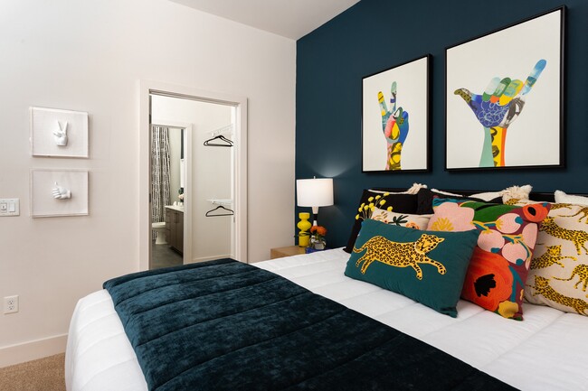 Dormitorio colorido con cojines decorativos y acceso al baño privado - 675 N. Highland