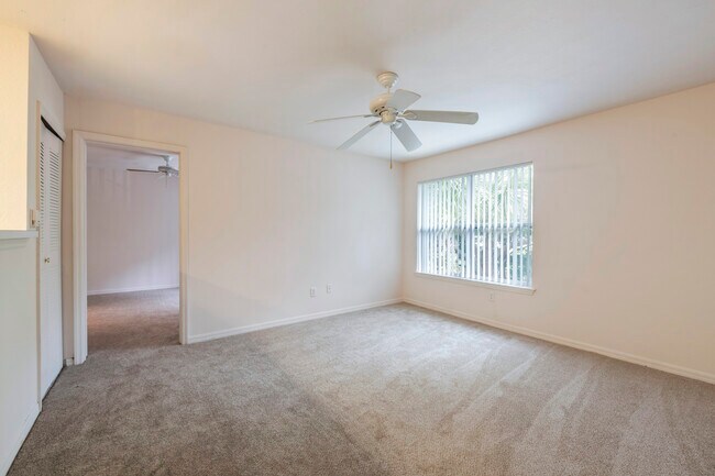 Bedroom with carpet flooring and large window for natural lighting - Park Villas Apartments