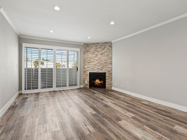 Hardwood floored living room with stone accented fireplace.