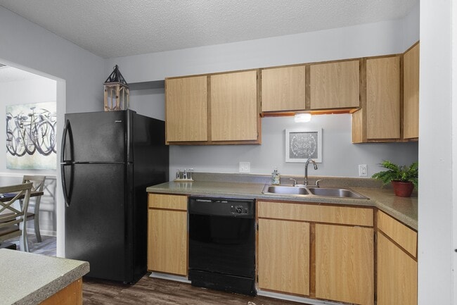 Sleek, matching black appliances and warm wooden cabinetry come together in the kitchens at Lakeland East Apartments in Flowood, MS. Managed by Highlands Vista Group.