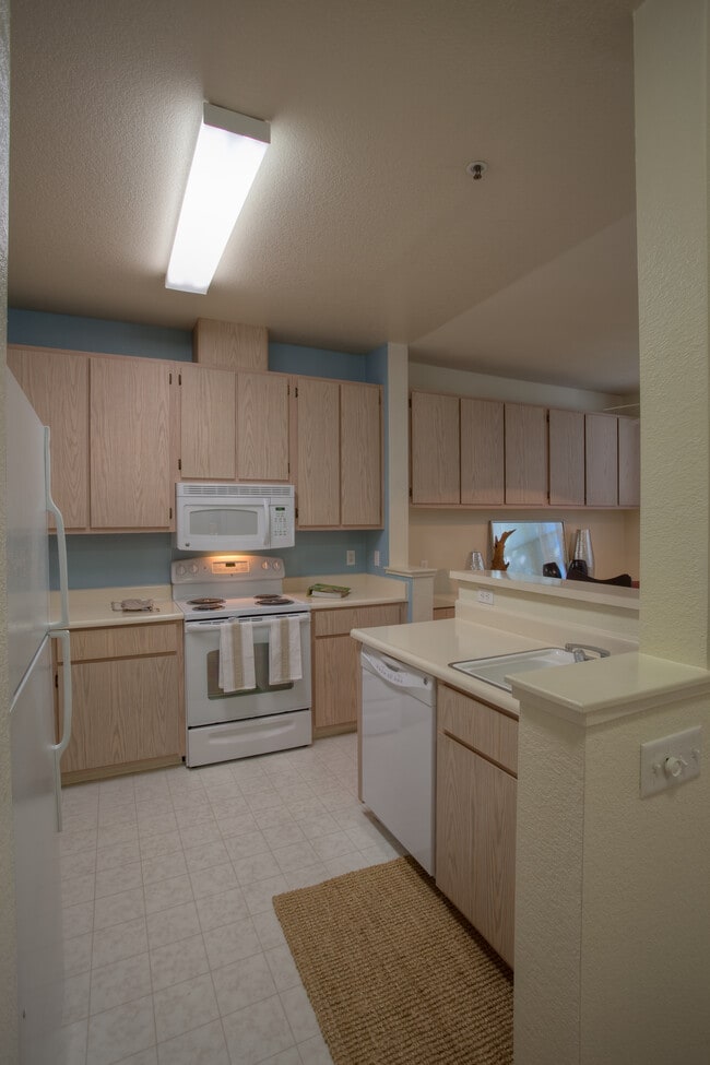 Classic Package I kitchen with light oak cabinetry, white laminate countertops, white appliances, and hard surface flooring
