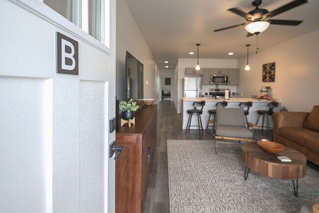 Inviting open-concept apartment with modern kitchen and cozy living area, perfect for relaxation and entertaining. - Orchard on Wallen