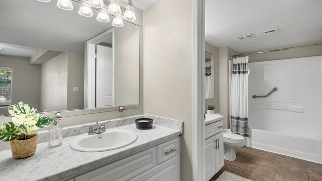 Newly remodeled bathrooms boasting marble-style countertops and ample mirrors.