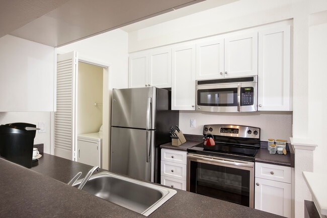 Classic Package I kitchen with stainless steel appliances, white cabinetry, laminate countertops, and hard surface flooring