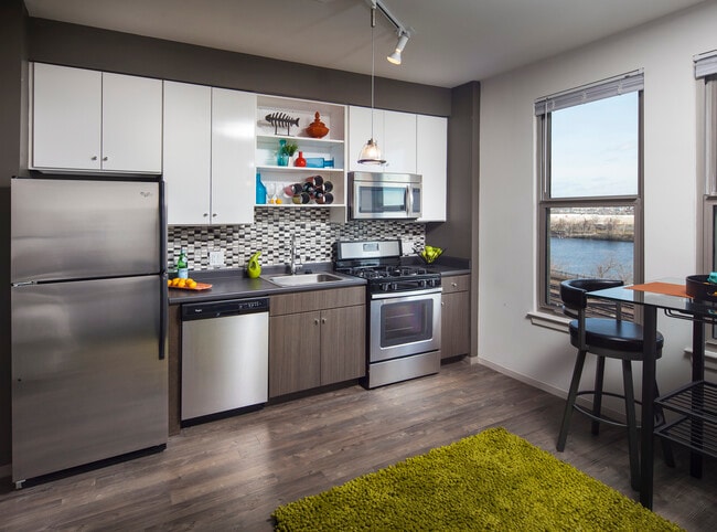Classic Package II kitchen with stainless steel appliances, dark laminate countertops, white and brown cabinetry, tile backsplash, and hard surface flooring