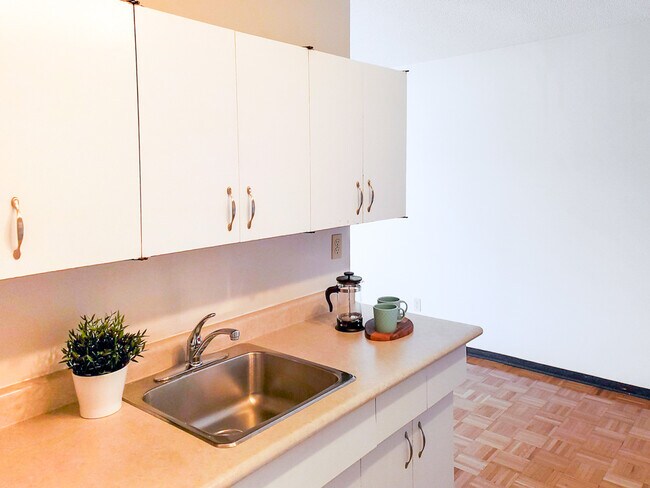 Enjoy a bright and functional kitchen at 1025 Munroe Apartments, featuring ample counter space and modern cabinetry - 1025 Munroe Avenue