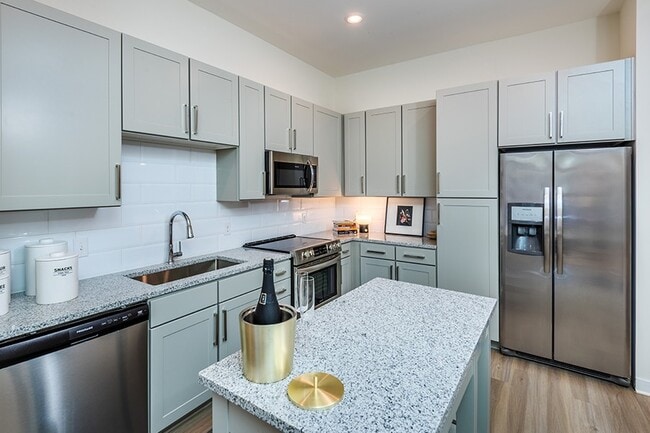 Kitchens include stainless steel appliances and 42" white or gray shaker-style cabinets