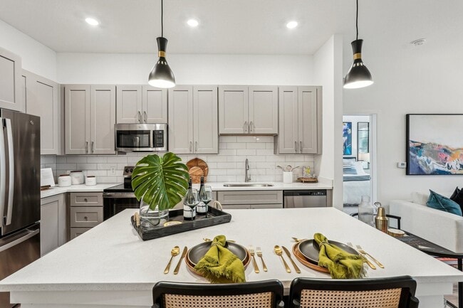 A modern kitchen with a dining table set for two.