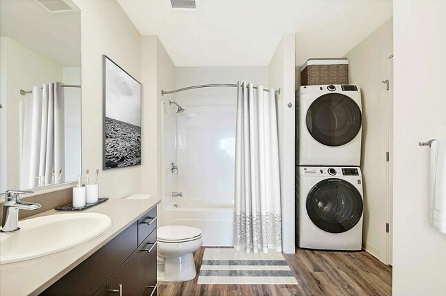 Experience convenience and style in this elegantly designed bathroom with integrated laundry.
