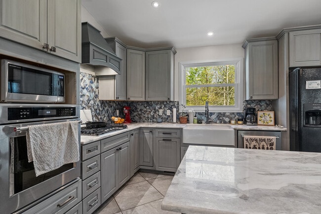 Cocina con armarios de cierre suave, electrodomésticos modernos y cocina de gas. - 358 Twin Oaks Dr