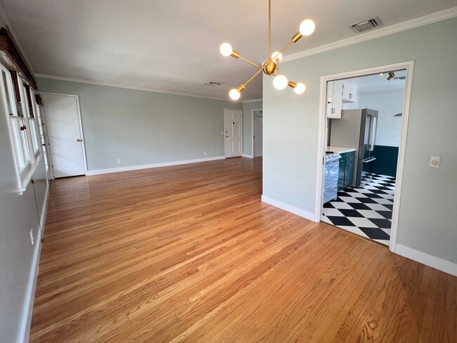 Dining area, living room on right, kitchen on left. Sputnik style brass chandelier. - 1327 N Central Ave Unidad #F