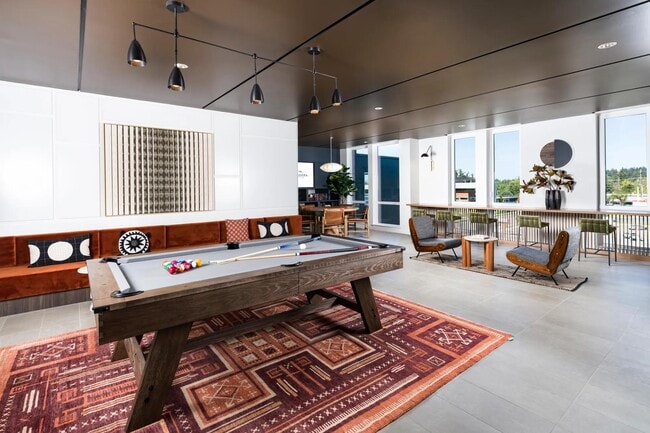 Level up your downtime in our game room—complete with billiards, shuffleboard, and a poker table. - Modera Raleigh Hills
