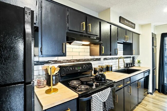 Experience the modern elegance of The WerX, featuring stylish black cabinetry and premium appliances in a spacious kitchen perfect for culinary enthusiasts. Elevate your lifestyle today and schedule a tour to see your future home!