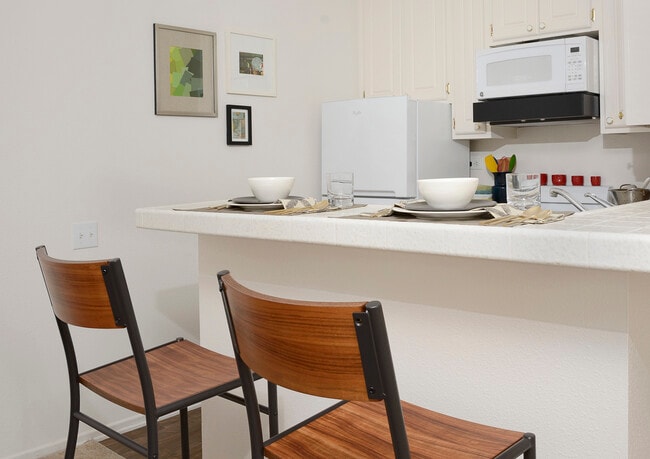 Classic Package I kitchen with white appliances, white tile countertops, white cabinetry, and hard surface flooring
