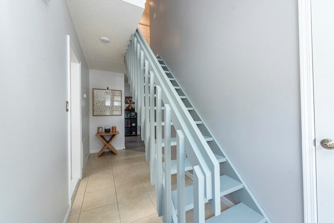 Bright, open staircase with solid railings leading to your private upper living spaces.