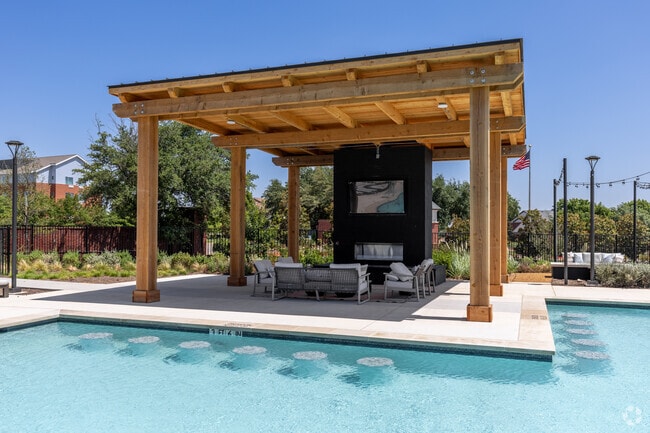 Salón al aire libre con chimenea y TV - The Dalton