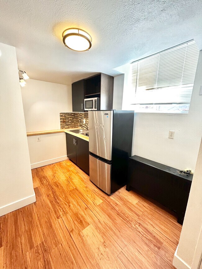 Chic modern kitchen with stylish backsplash, sleek cabinetry, and natural light highlighting the hardwood floors.