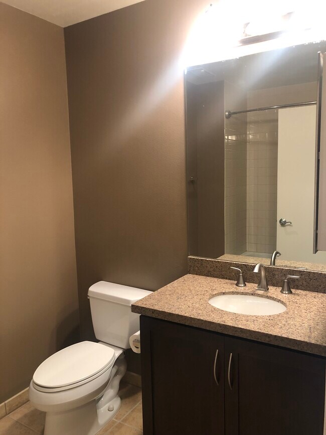 Full Bath with granite countertops, dark wood cabinets, & tile floors