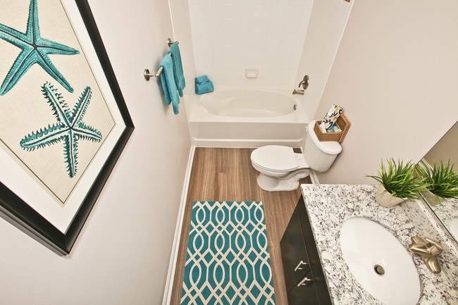 Baño renovado con pisos de madera y encimeras de granito - Woodland Park