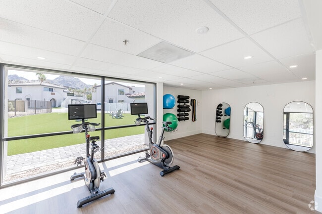Sala de bienestar con bicicletas de spinning, estaciones de cardio y áreas de yoga y estiramiento.