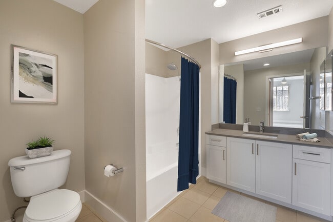 Renovated Package I bath with white cabinetry, grey quartz countertops, and hard surface flooring