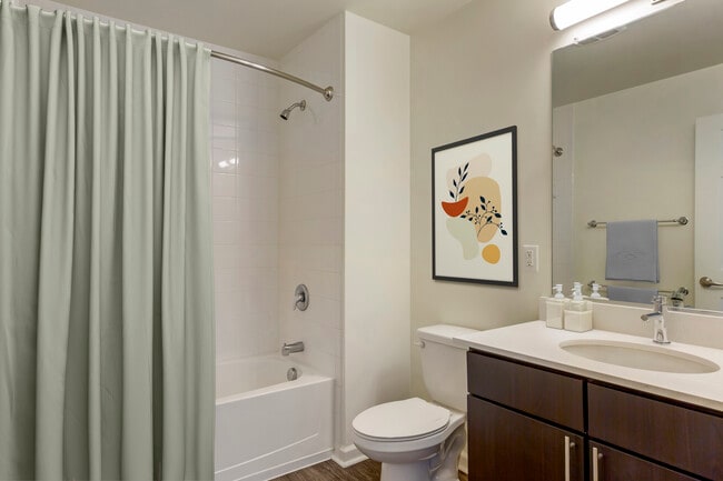 Renovated Package I bath with white quartz countertops, espresso cabinetry, and hard surface flooring