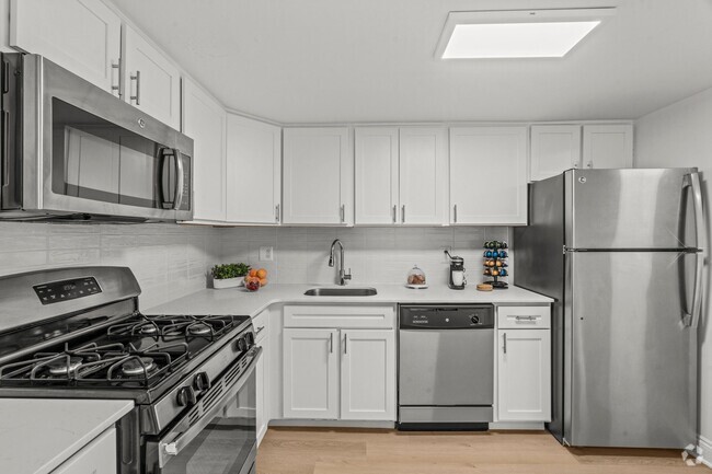 kitchen with white cabinets and stainless steel appliances - Chestnut Hill Village Apartments