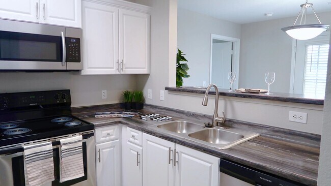 Revel in premier kitchens boasting black fusion granite-inspired countertops and modern white cabinetry for a chic culinary experience.