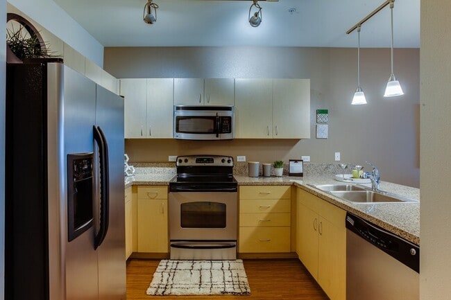 Abierto de cocina cuenta con hermosas encimeras de granito con placa para salpicaduras de granito de seis pulgadas y pisos de tablones de vinilo de lujo - The Matisse