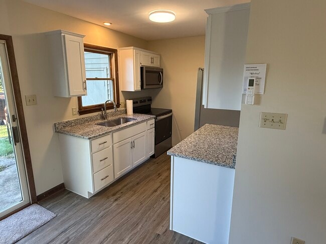 Modern kitchen features new cabinetry, granite countertops, and stainless steel appliances - 1004 Corbett St Unit 1004