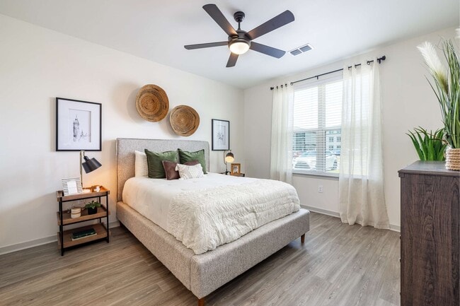 Cozy bedroom with ceiling fan and attached private bathroom at The Groves at Lake Juliana