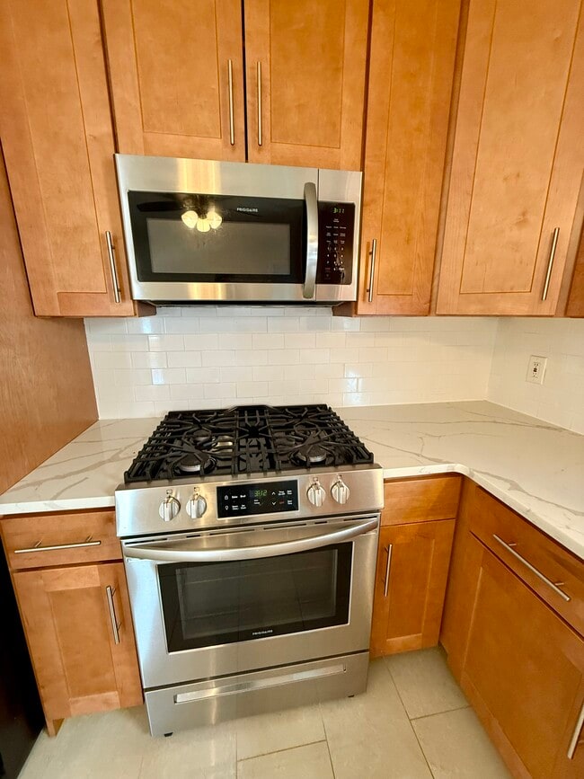 Updated kitchen with quartz counters and stainless steel appliances - 60 Baltimore Ave Unit 1