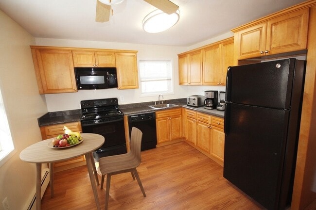 Elevate your lifestyle at Treetop Apartments with a welcoming kitchen featuring modern appliances, warm wood cabinetry, and inviting dining space. Perfect for culinary enthusiasts and casual gatherings. Schedule a tour today to see for yourself!