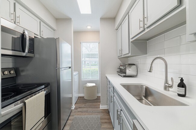 Kitchen with quartz countertops and stainless steel appliances - Oakgate at Pecan Grove