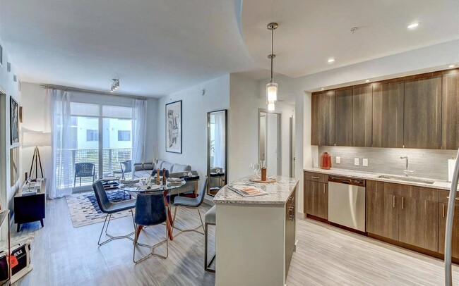 La cocina cuenta con gabinetes superiores largos, iluminación incorporada y electrodomésticos de acero inoxidable. - Pearl Flagler Village