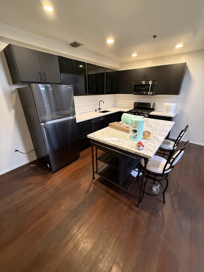 Fully upgraded and remodeled gourmet kitchen with quartz countertops and stainless steel appliances - 900 N Hoover Apartments