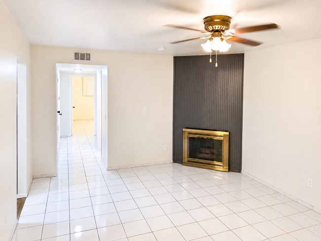 Spacious living room featuring a decorative fireplace, neutral walls, tile flooring, and a comfortab - 339 E Taft Ave Unit 2