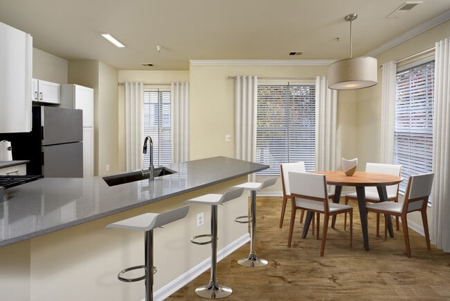 Renovated Package I kitchen with stainless steel appliances, grey quartz countertops, white cabinetry, and hard surface flooring