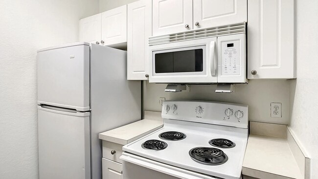 Step into an inviting kitchen featuring white appliances, ample cabinet storage, and durable countertops.