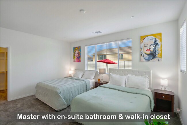 Master bedroom featuring an en-suite bathroom and a spacious walk-in closet.