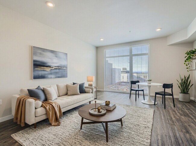 Open living layout at 306 Queen Anne featuring wood-style flooring, natural window light, and room for a dining table.