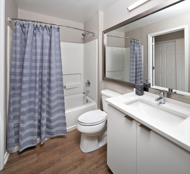 Premier Scheme bath with white flat cabinetry, white marbled quartz countertops, and hard surface flooring